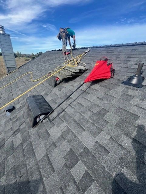 SunSafe Shield umbrella laid on the roof while roofers work nearby